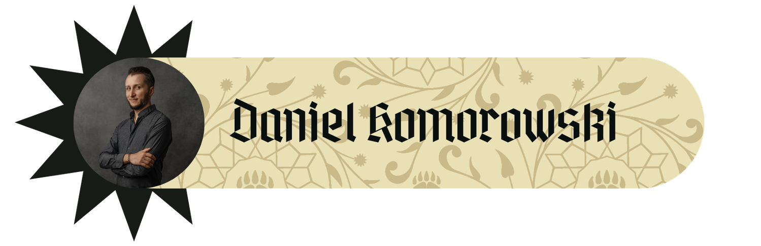 Daniel Komorowski – baner gościa RawiKonu ze zdjęciem portretowym pisarza w ciemnej koszuli